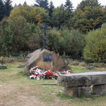 Kamienny obelisk z krzyżem i pamiątkową tablicą na Suchej Polanie
