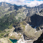 Widok z grani pod szczytem Rysów w głąb Doliny Ciężkiej, do której opada pionowa ściana Ganku (2462 m), a nad nimi góruje Gerlach (2655 m)