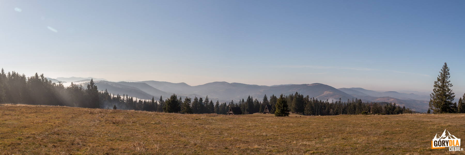 Panorama z górnej części Hali Krawcula: od lewej Mała Fatra, Świtkowa (1082 m), Rycerzowa Wielka (1226 m) i Rycerzowa Mała (1207 m), Wielka Racza (1236 m), Muńcuł (1165 m), Praszywka Wielka (1043 m), Magura (1073 m), Oźna (952 m), Rochowiec (954 m) i Sucha Góra (1040 m), a na hali szałas, Bacówka PTTK i krzyż